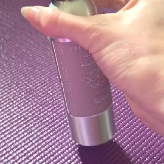 Lavender yoga mat spray from Cloudscape Hill misting onto a rolled-out mat — a calming, antibacterial ritual after practice