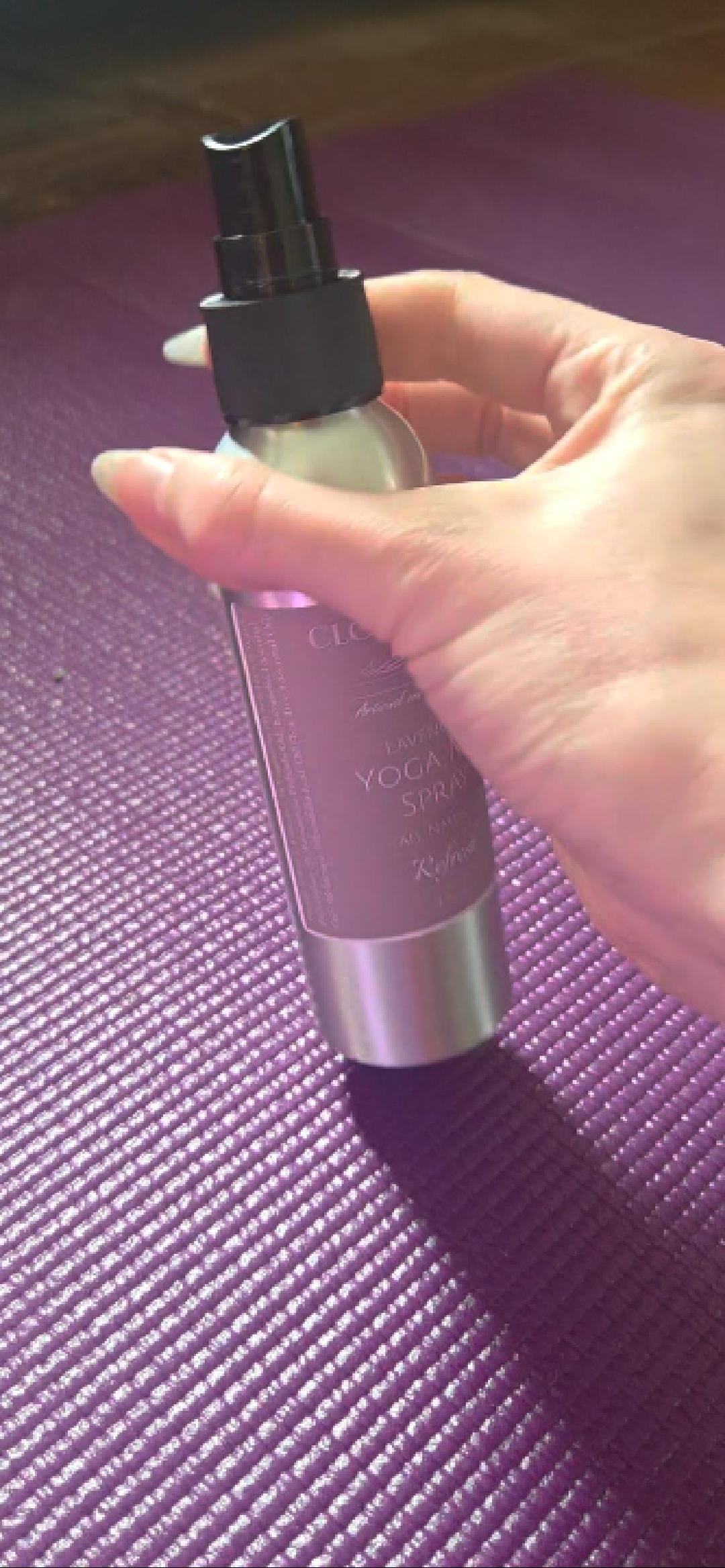 Lavender yoga mat spray from Cloudscape Hill misting onto a rolled-out mat — a calming, antibacterial ritual after practice