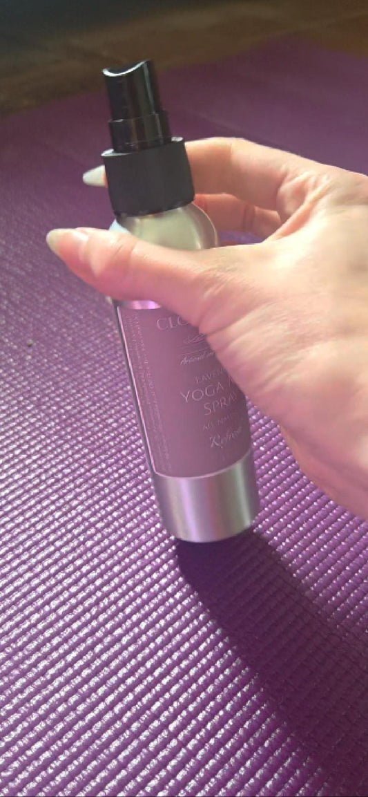 Lavender yoga mat spray from Cloudscape Hill misting onto a rolled-out mat — a calming, antibacterial ritual after practice